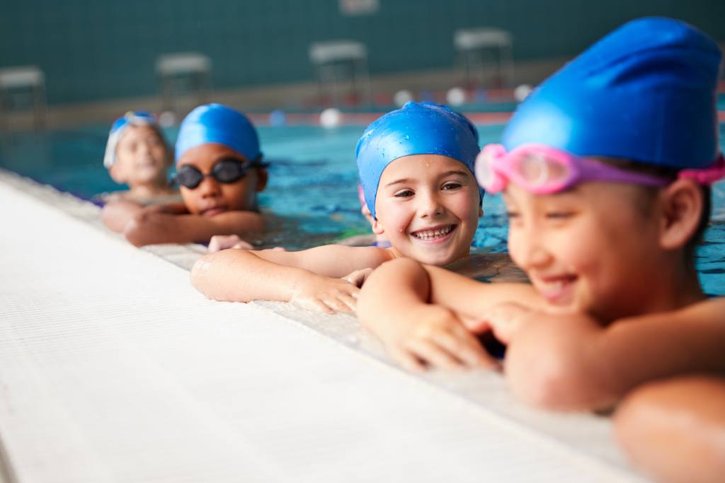A group of smiling little girls in a swimming pool